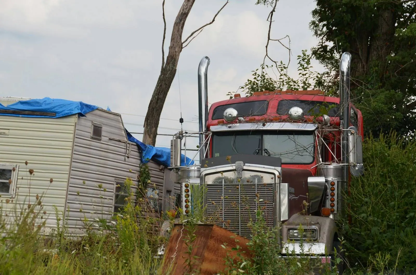 An old semi truck left standing in a field