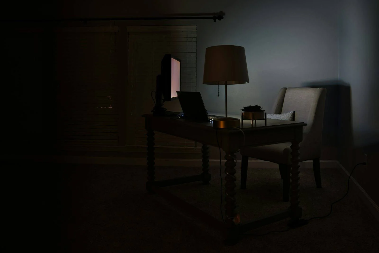 A dark home office lit only by a screen